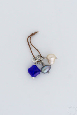 Three pack charms on a string on a white background