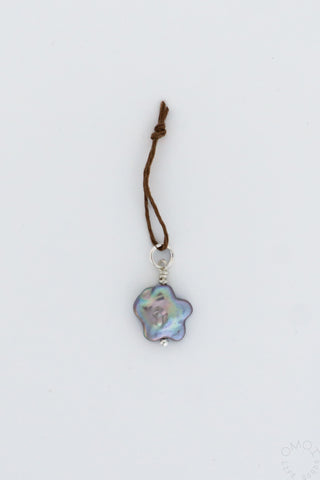 Baby star pearl charm hanging on string on a white background