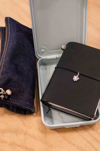 Black notebook with star pearl charm inside of an open toolbox