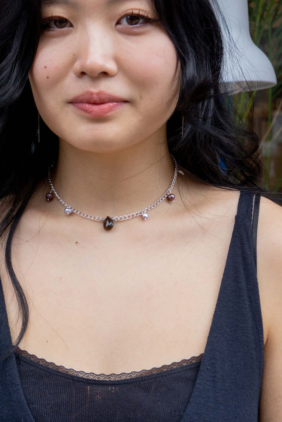 Cropped shot of person wearing tear necklace