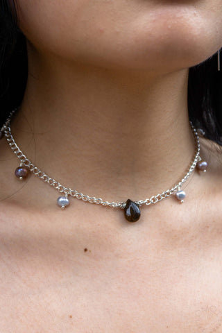 Close-up of tear necklace on a person