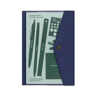 A navy blue monthly planner set with a snap-button closure, shown open to reveal a printed insert of example items you can hold inside the pocket section, including pens, ruler, stickers, etc.