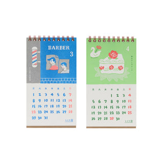 Two spiral-bound desk calendars shown side by side on a plain white background. The left calendar has a blue upper section with barber-themed illustration and the right has a rose decorated slice of cake