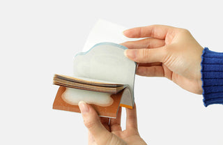 Person holding open a memo pad against a white background