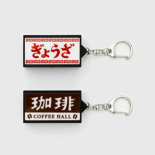 Two keychains with Japanese text and graphics on a white background