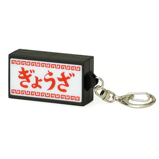 White and red rectangular keychain  featuring red text on a white background