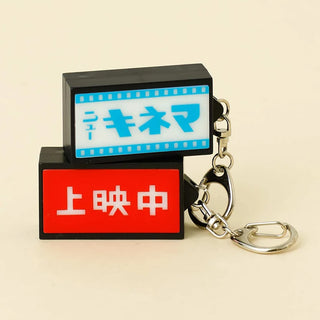 Keychain with movie theater sign design on a beige background