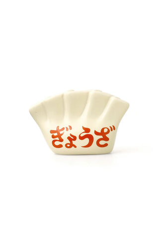 White ceramic pen holder in the shape of a dumpling with red text on a white background
