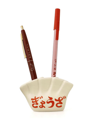 White dumpling pen holder with red Japanese text holding two pens on a white background