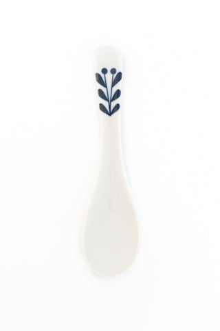 White ceramic spoon with blue leaf design on a white background