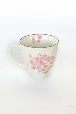 White mug with pink floral design on a white background