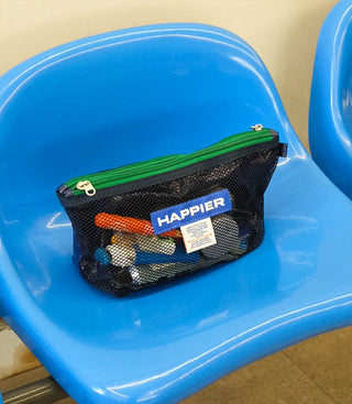 Mesh pouch with toys labeled 'HAPPIER' on a blue chair
