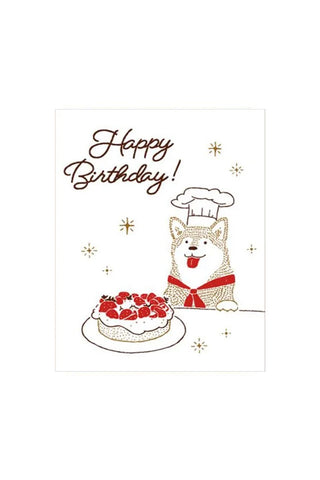 Birthday card with a dog in a chef's hat and cake, featuring 'Happy Birthday!' text.