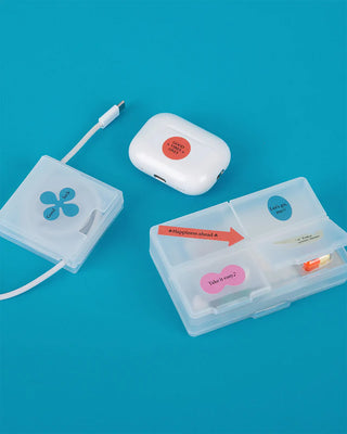 Stickers on ear bud case and plastic containers on a blue background