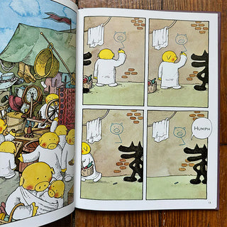 Page with cartoon characters and a black wolf on a wooden surface