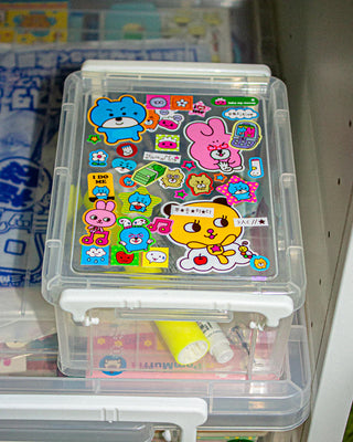 Clear storage box with colorful cartoon stickers on a shelf.