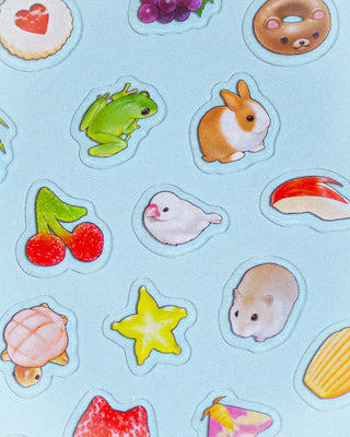 Collection of colorful animal and fruit stickers on a light blue background
