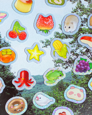 Collection of colorful stickers featuring various animals and objects on a nature-themed background.