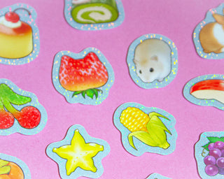 Stickers of a hamster, strawberry, corn, and other food items on a pink background