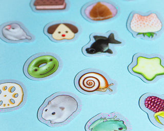 Collection of cute, cartoon-style animal and food stickers on a light blue background