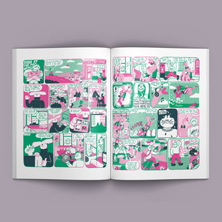 Magazine pages filled with a colorful comic strip panel layout in pink, green, black, and white, photographed against a lavender-gray background.
