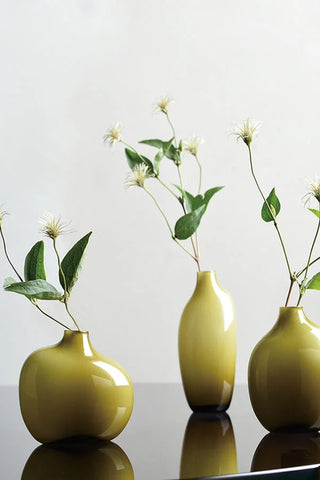 Set of three olive green glass vases with bulbous shapes and glossy finish