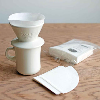 White coffee filter set on a wooden surface with a white background