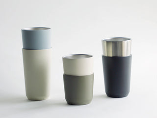 Set of ceramic tumblers with different color combinations on a white background
