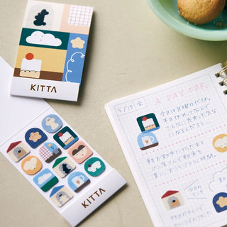Kitta sticker books with stickers in a notebook on a table