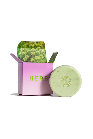 Green soap bar with pink packaging on a white background