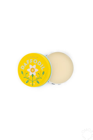 Opened container of Kala Daffodil Lip Balm with yellow packaging on a white background