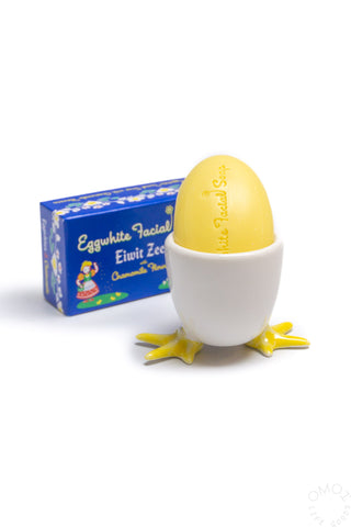 White ceramic egg soap cup with yellow soap inside on a white background