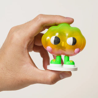 Hand holding a colorful toy figure with a white background