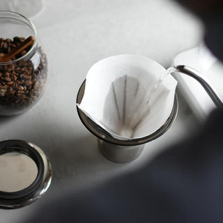 Water pouring into coffee carafe with filter