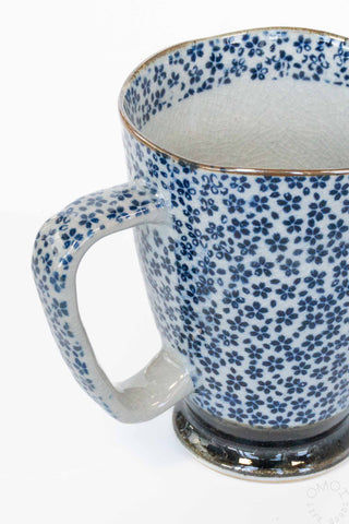 Ceramic mug with blue floral pattern on a white background