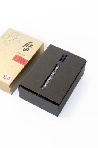 Black rectangular box with a pen and beige box with brand logo on a white background