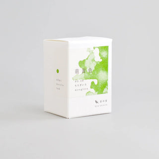 bottled ink product box with a green watercolor-style label on the front, on a light background.