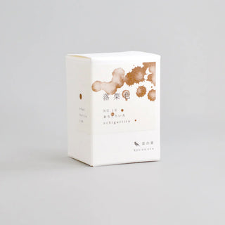 bottle ink product box with brown ink-splatter graphics and Japanese text, on a light background.