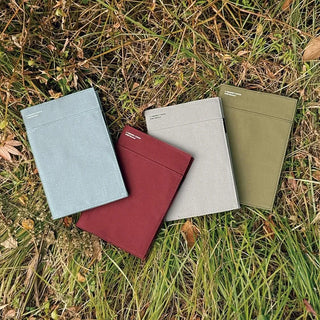 Four colorful notebook covers on grass