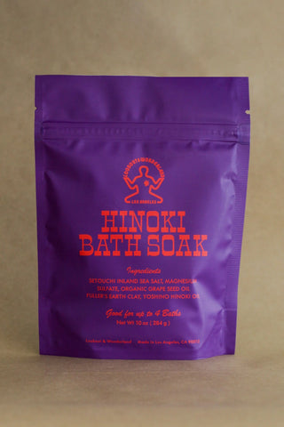 Purple package of Hinoki Bath Soak on a beige background