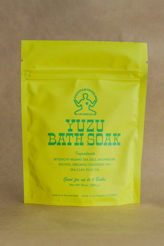 Yellow package of Yuzu Bath Soak on a brown background