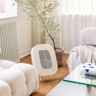 Modern living room with a white geometric-air purifier, plant, and glass coffee table.