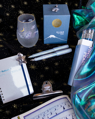Two Kaweco perkeo pens on a black fabric star background with stationery