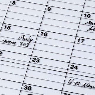 Close-up of a calendar with handwritten notes and dates