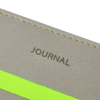 Close-up of a journal cover with 'JOURNAL' text and a green band on a beige background