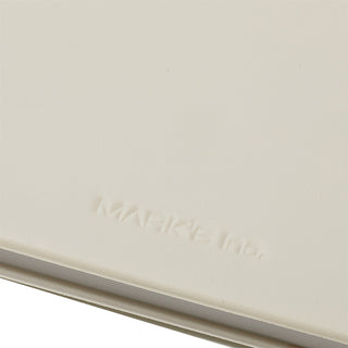 Close-up of a beige notebook with 'Mark's Inc.' embossed on it.