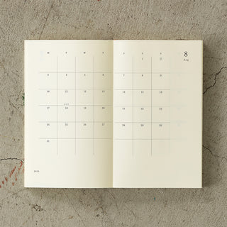 Open calendar showing August on a textured stone surface