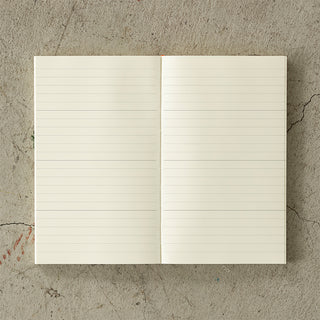 Open notebook with lined pages on a textured concrete surface