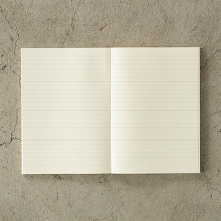 Open notebook with lined pages on a textured concrete surface