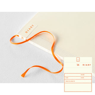 Diary with orange ribbon bookmark on a light gray background